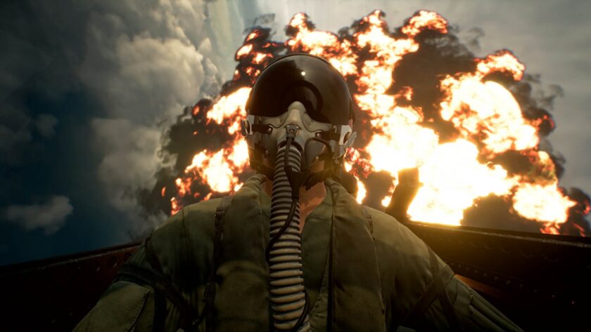 A fighter pilot in helmet and oxygen mask against a backdrop of fire and smoke — Ace Combat 8: Wings of Theve launches October 1 to strong reviews