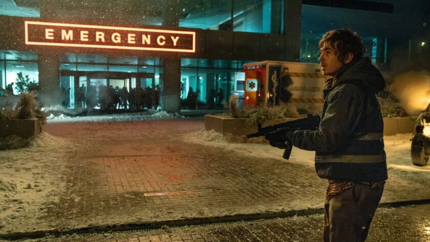 Austin Abrams as medical courier Bryan in the Resident Evil movie, facing the outbreak outside a Raccoon City hospital